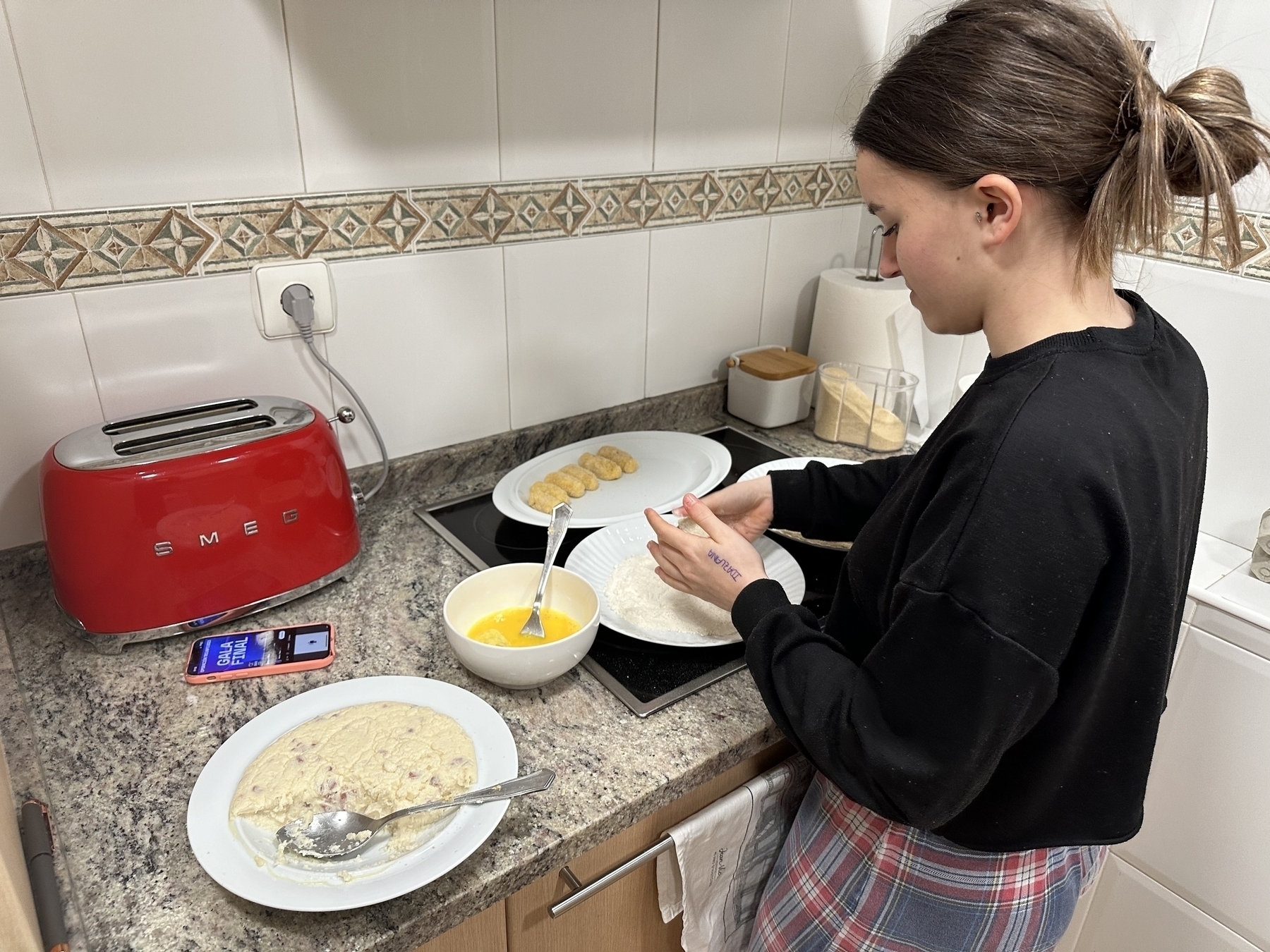 Picture of a teenager, my daughter, making croquetas in a kitchen. 